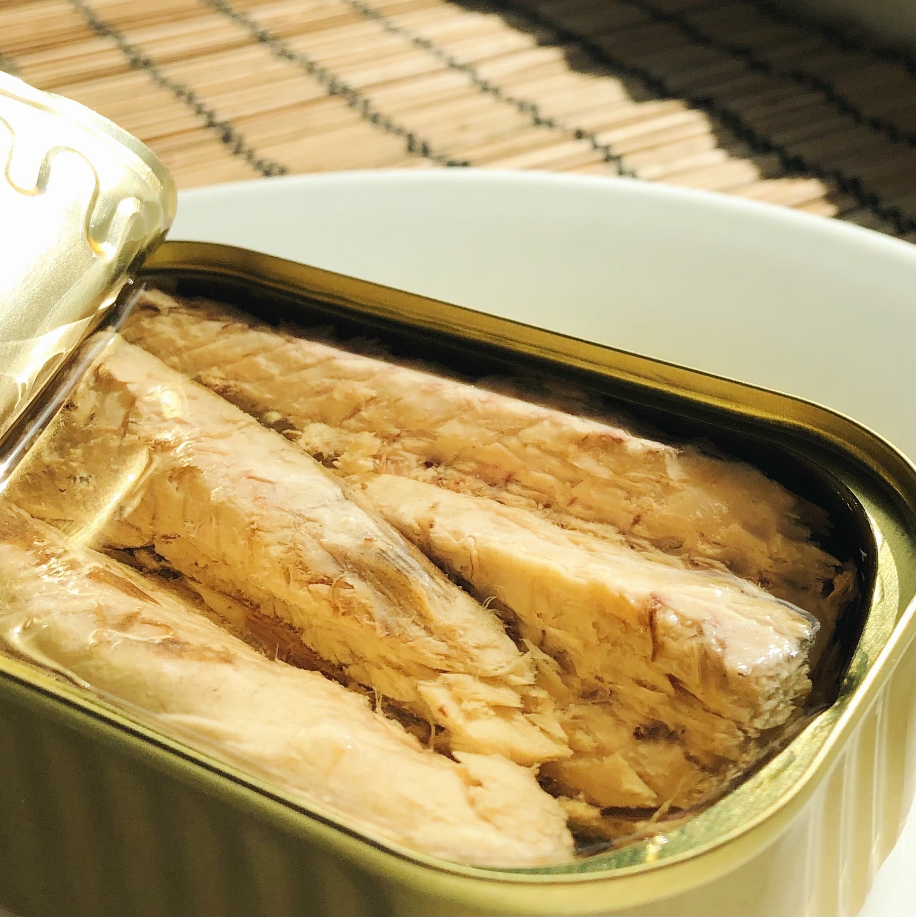A tin of mackerel fillets in olive oil beside a window - Donostia Foods