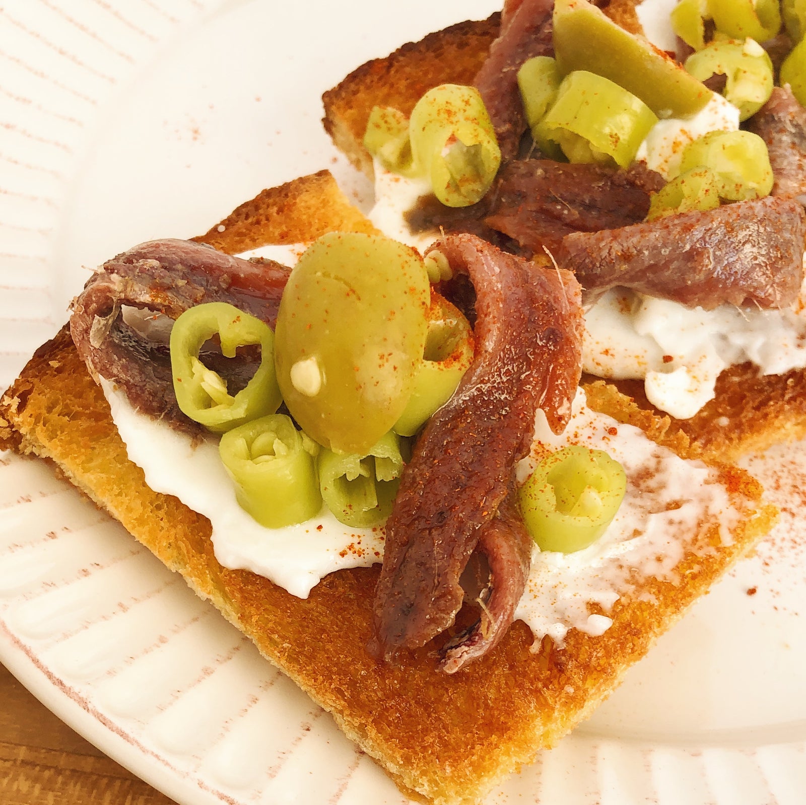 Cantabrian anchovies with guindilla peppers, manzanilla olives, and lemon garlic sauce - Donostia Foods