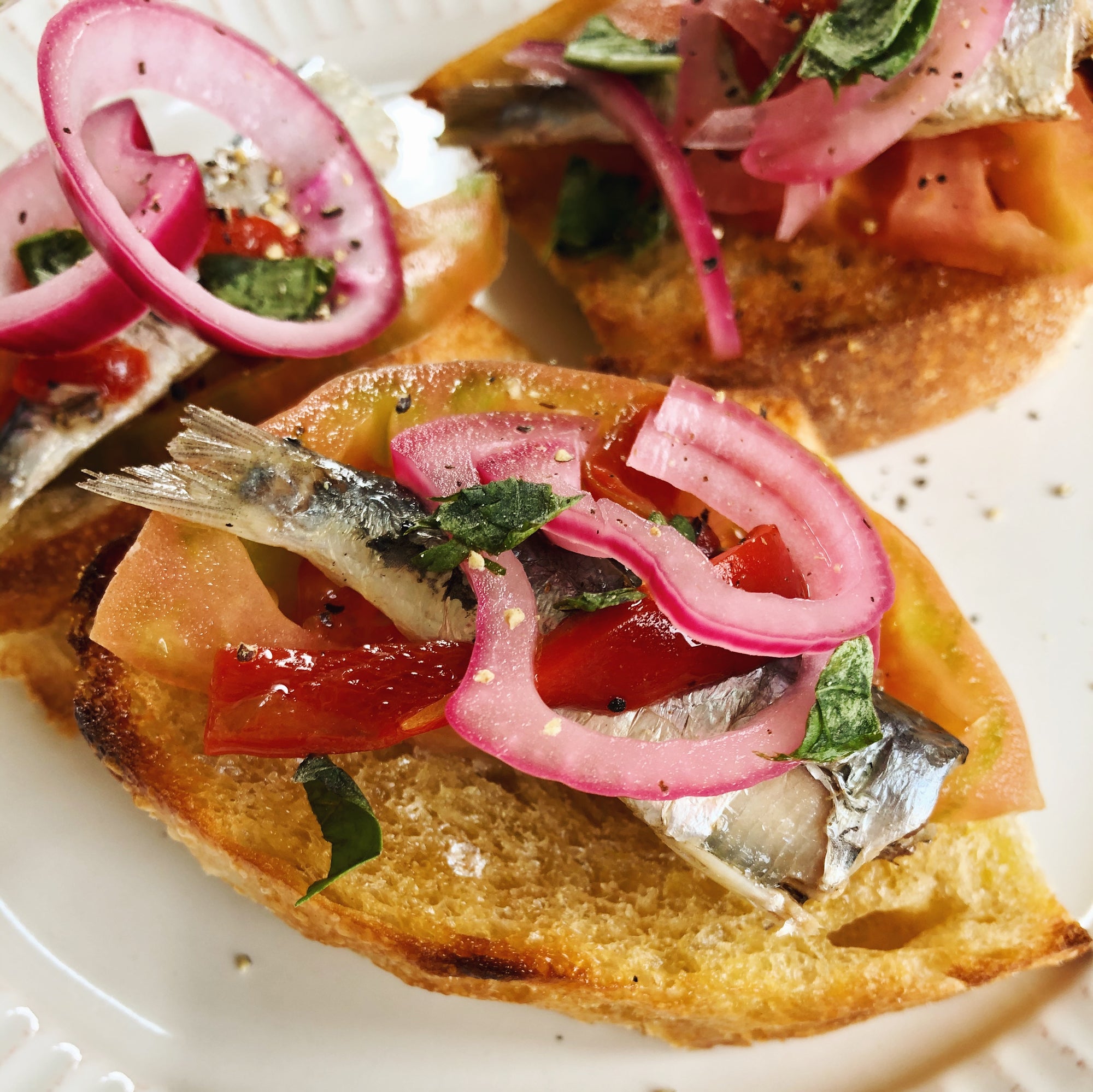 Sardinillas with piquillo pepper and pickled onions on garlic toast