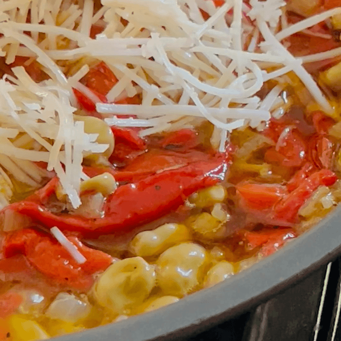 Baby Broad Beans and Piquillos (Vegan Version) sizzling in a saucepan - Donostia Foods
