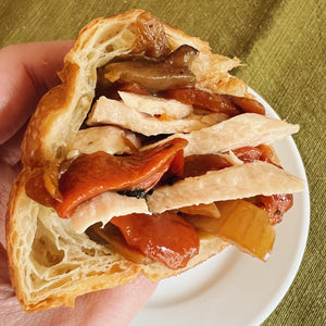 A buttery croissant stuffed full of ventresca tuna, roasted peppers, eggplant, and onion.